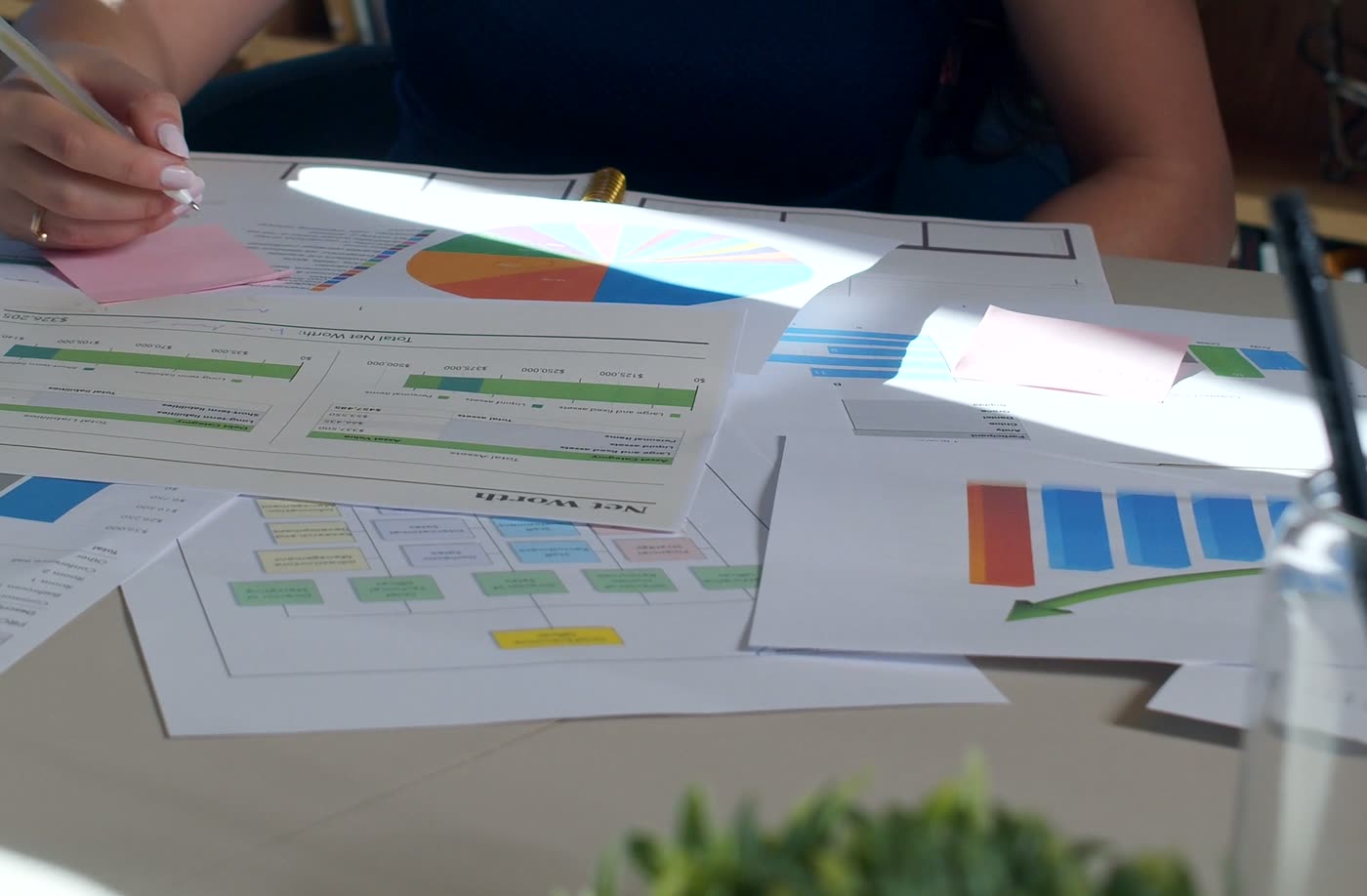 Handen wijzen cijfers aan op een rapport met staafdiagrammen